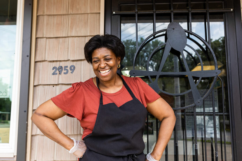 Small business owner Angelynn Howell smiles outside the door to her restaurant