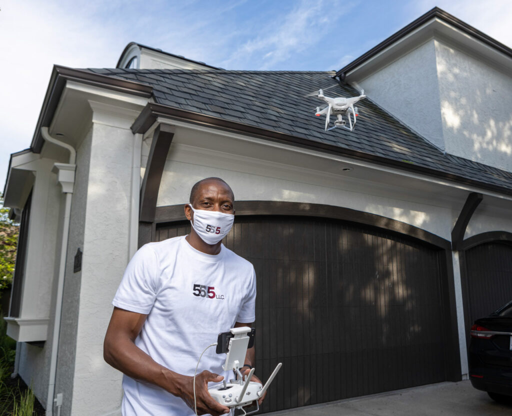 Small business owner Reggie Hines controls a done to check a roof